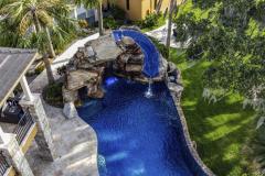 Evening view of waterslide with soft lighting reflecting on the serene pool surface.