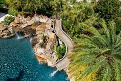 Aerial perspective of a waterslide winding into the pool.