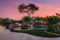 Signature Series Insane Pool with grotto and rain curtain at night